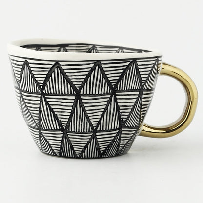 Tasse avec motif géométrique abstrait et anse dorée