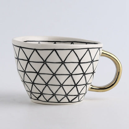 Tasse avec motif géométrique abstrait et anse dorée