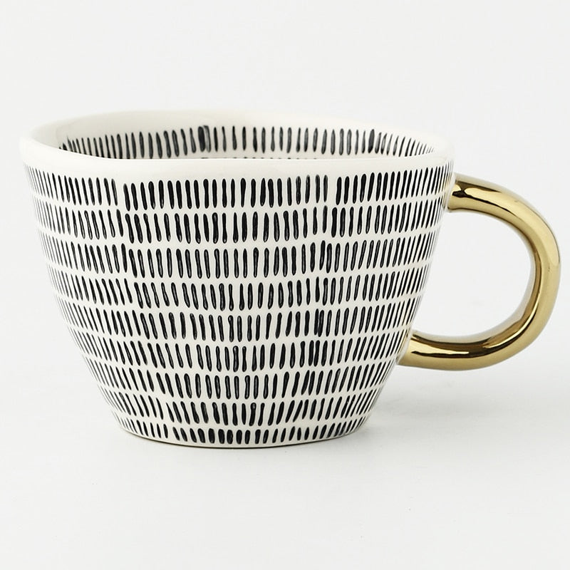 Tasse avec motif géométrique abstrait et anse dorée