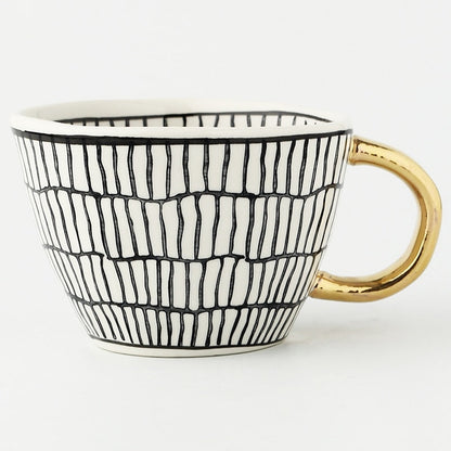 Tasse avec motif géométrique abstrait et anse dorée