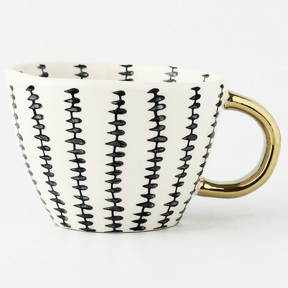 Tasse avec motif géométrique abstrait et anse dorée