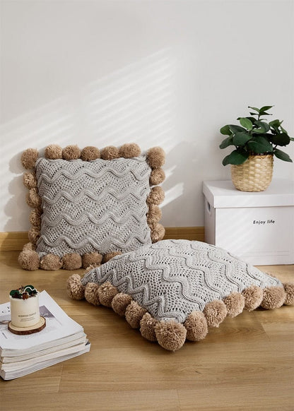 Coussin en tricot avec pompons